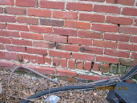 Mortar missing in brick masonry wall allows water into interior of building.